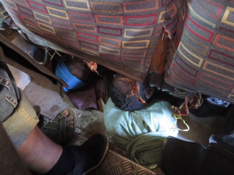 バスの座席の下で寝る夫婦
